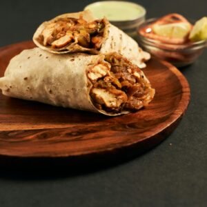 Mouth-watering chicken wraps served with dips on a wooden plate, perfect for lunch.