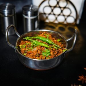 Vibrant spicy curry dish with greens, captured in a traditional kitchen setting.