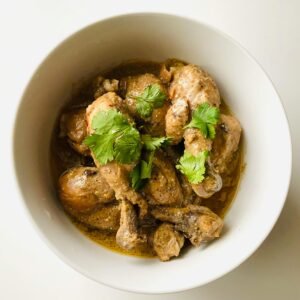 A tempting bowl of chicken curry garnished with fresh cilantro, perfect for Asian cuisine lovers.