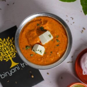 A mouth-watering overhead view of paneer makhani with creamy texture, garnished with herbs.