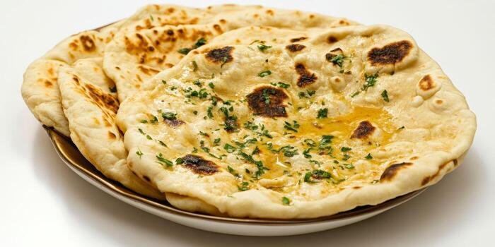 freshly-baked-indian-butter-naan-with-herbs-on-a-white-plate-photo butter naan