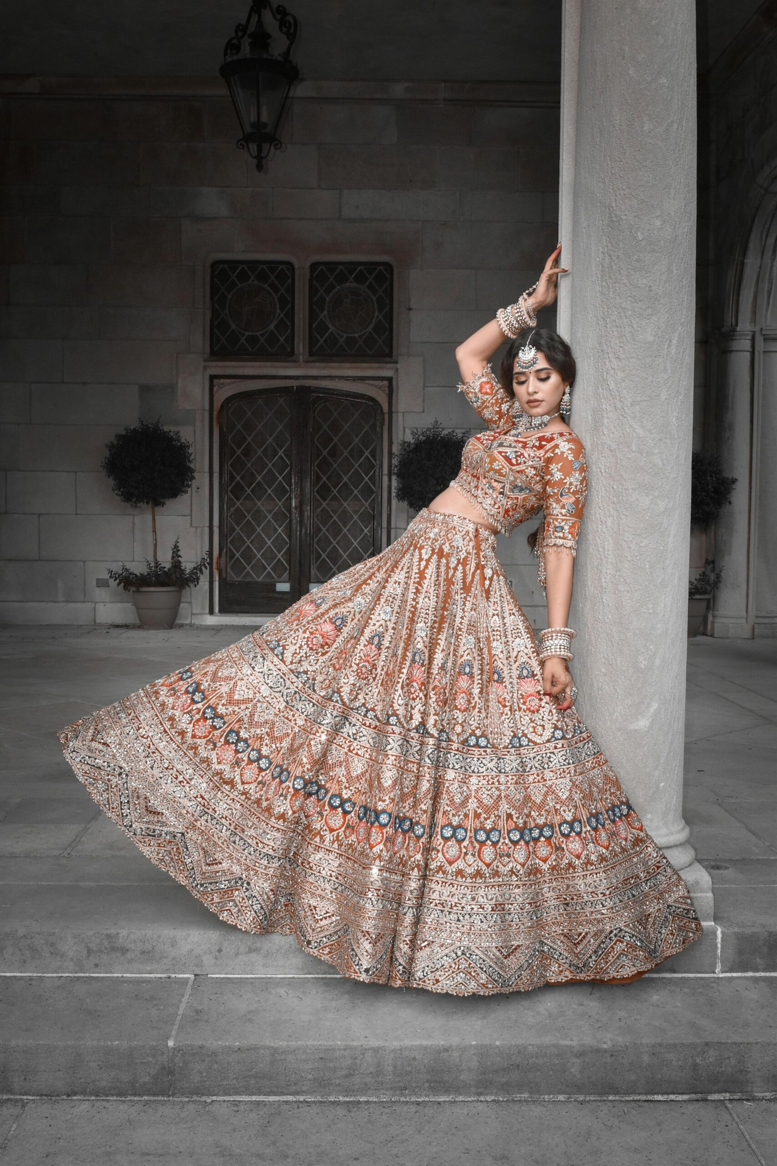 Elegant Indian bride in traditional attire posing gracefully near a pillar. Perfect for cultural themes.